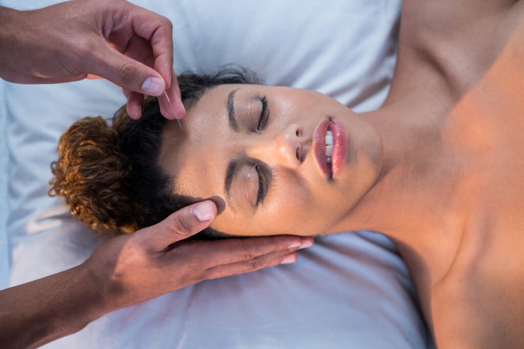 Woman receiving head massage from physiotherapist in clinic